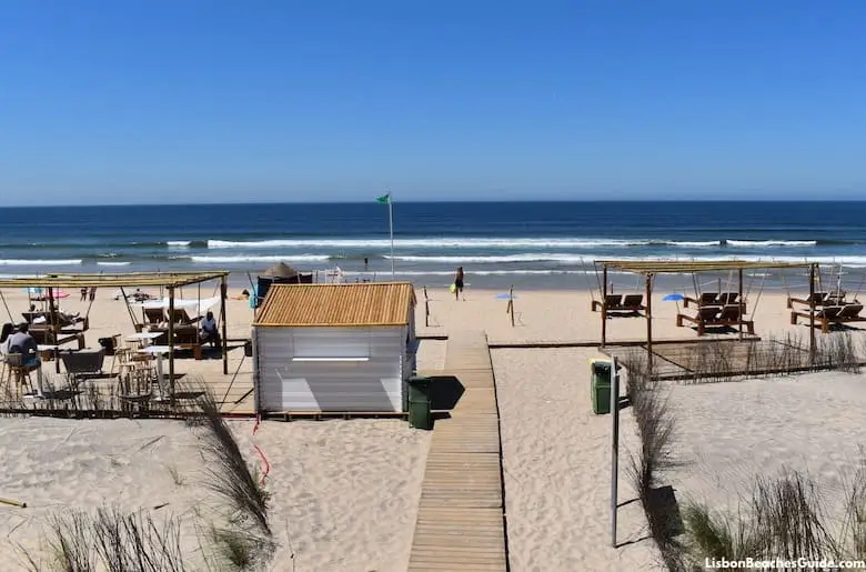 Wooden boardwalk leading to beach huts and ocean