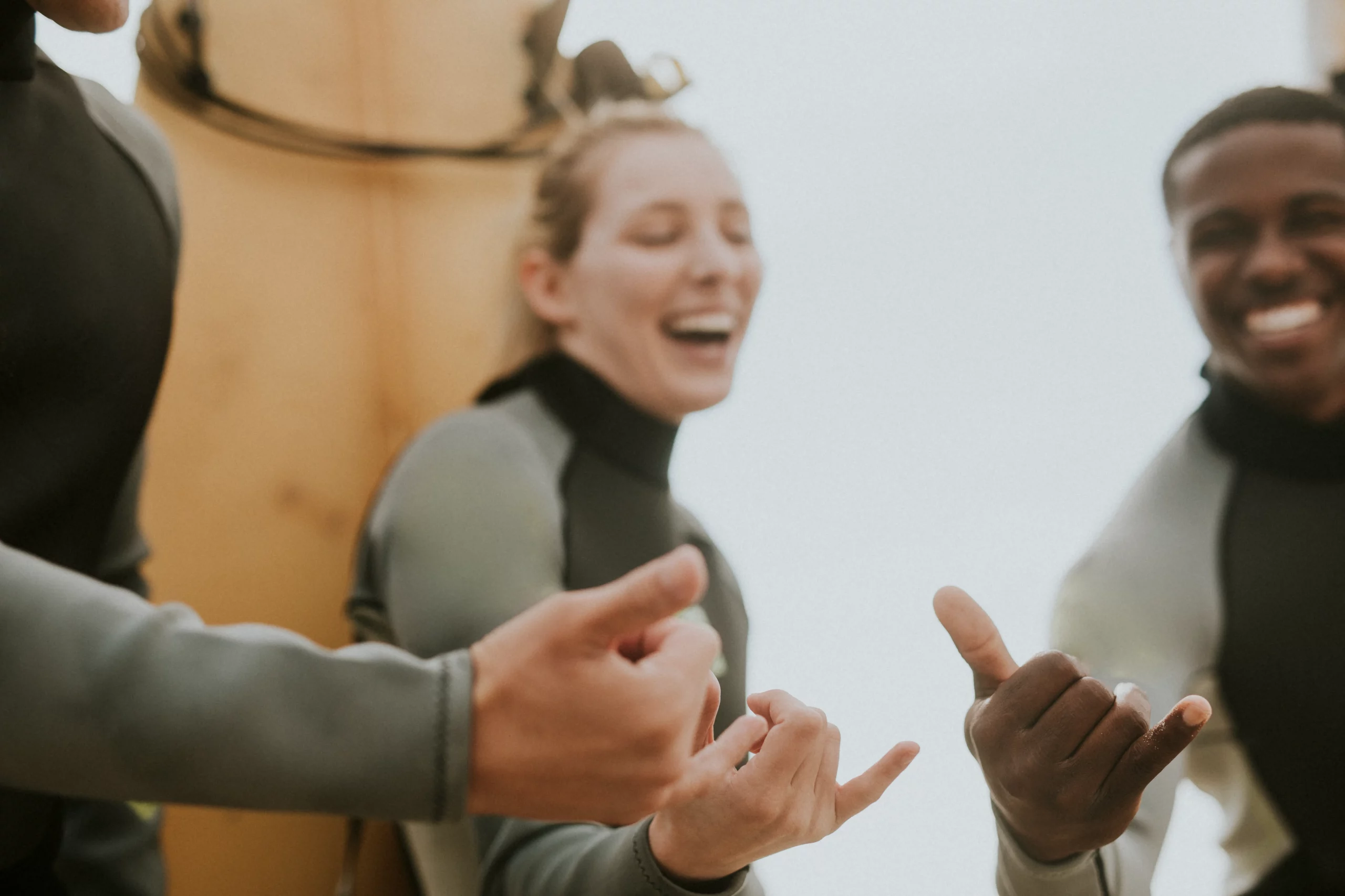 Group of surf students smiling and making the shaka sign after a surf session